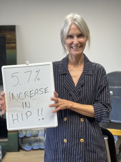 OsteoStrong member Valerie S. holding her whiteboard with DEXA numbers