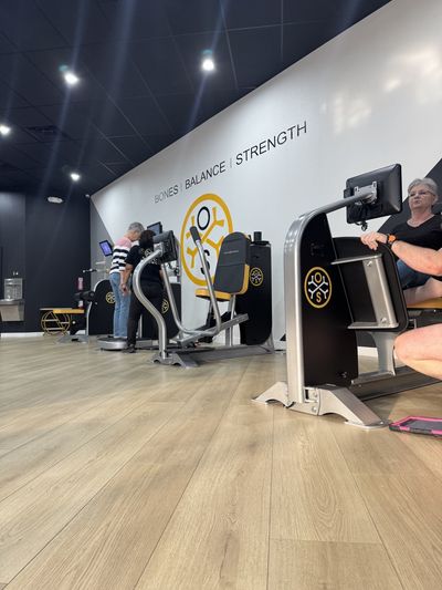 Members on the OsteoStrong bones, balance, and strength devices inside the Austin center